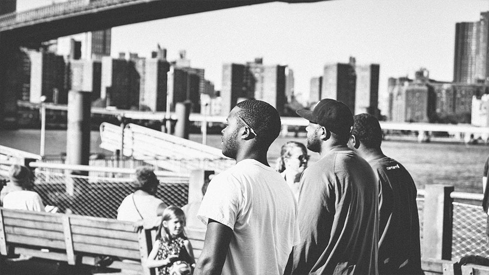 Men at an East River railing with the Manhattan skyline - New Yorkers by Lebrvn Creations