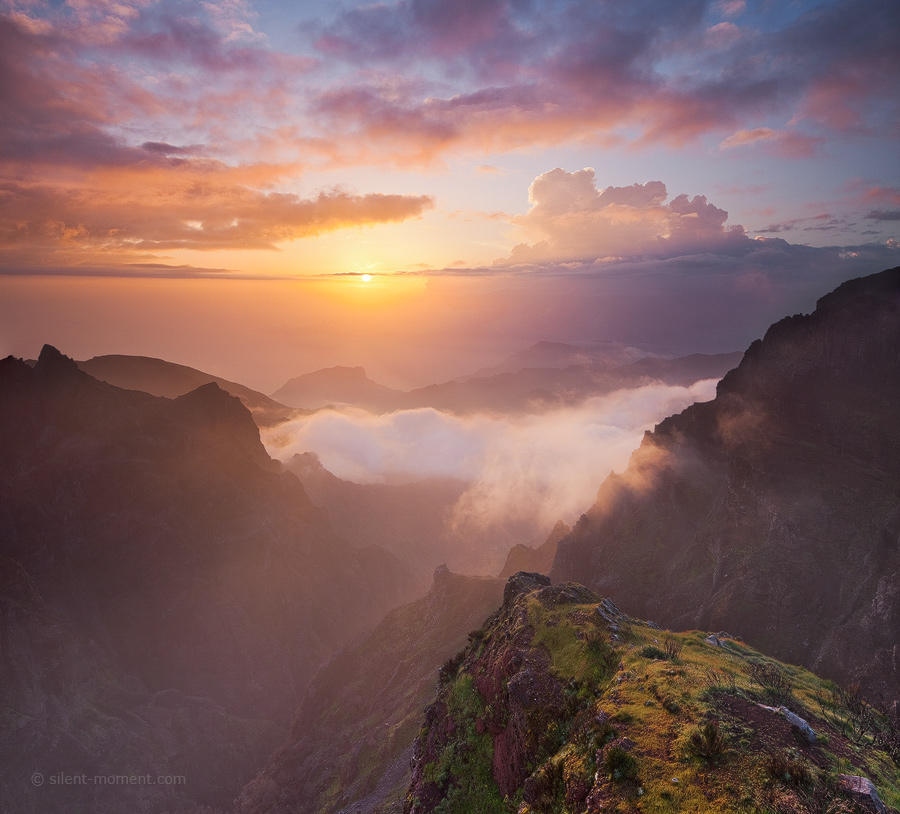 Warm low sunlight above mountain ridges and mist filling a valley