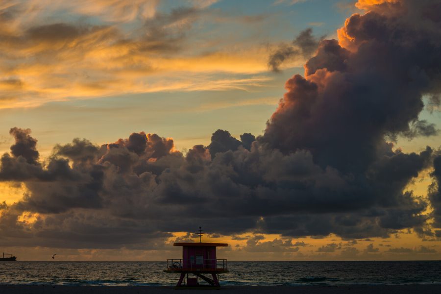 Sunrise storm clouds over a Miami Beach lifeguard tower and the sea