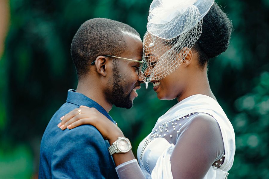 A wedding couple facing each other in a close outdoor embrace