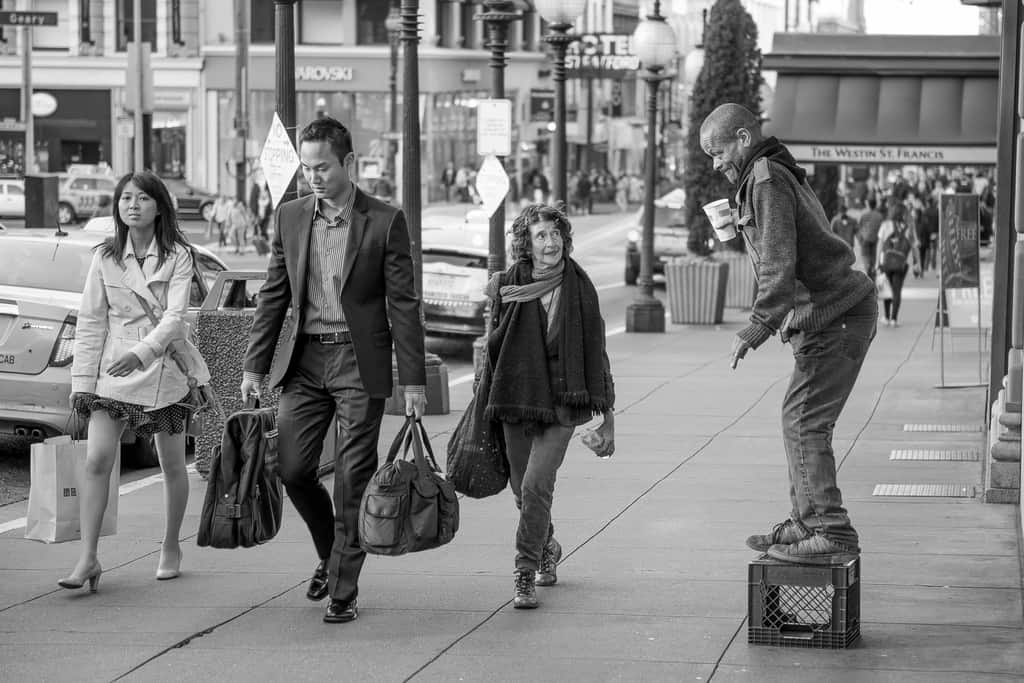 San Francisco street photograph of pedestrians passing a performer on a crate