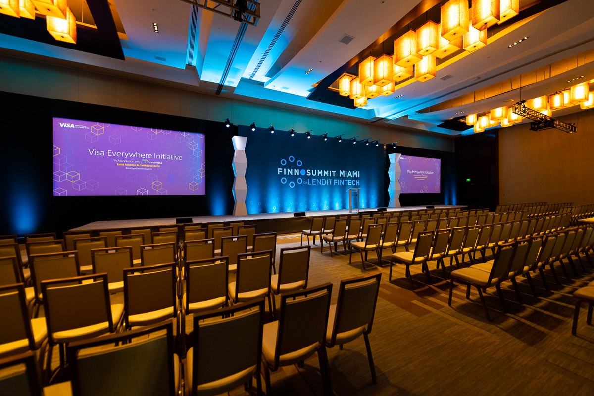 Conference room with rows of chairs and illuminated presentation screens