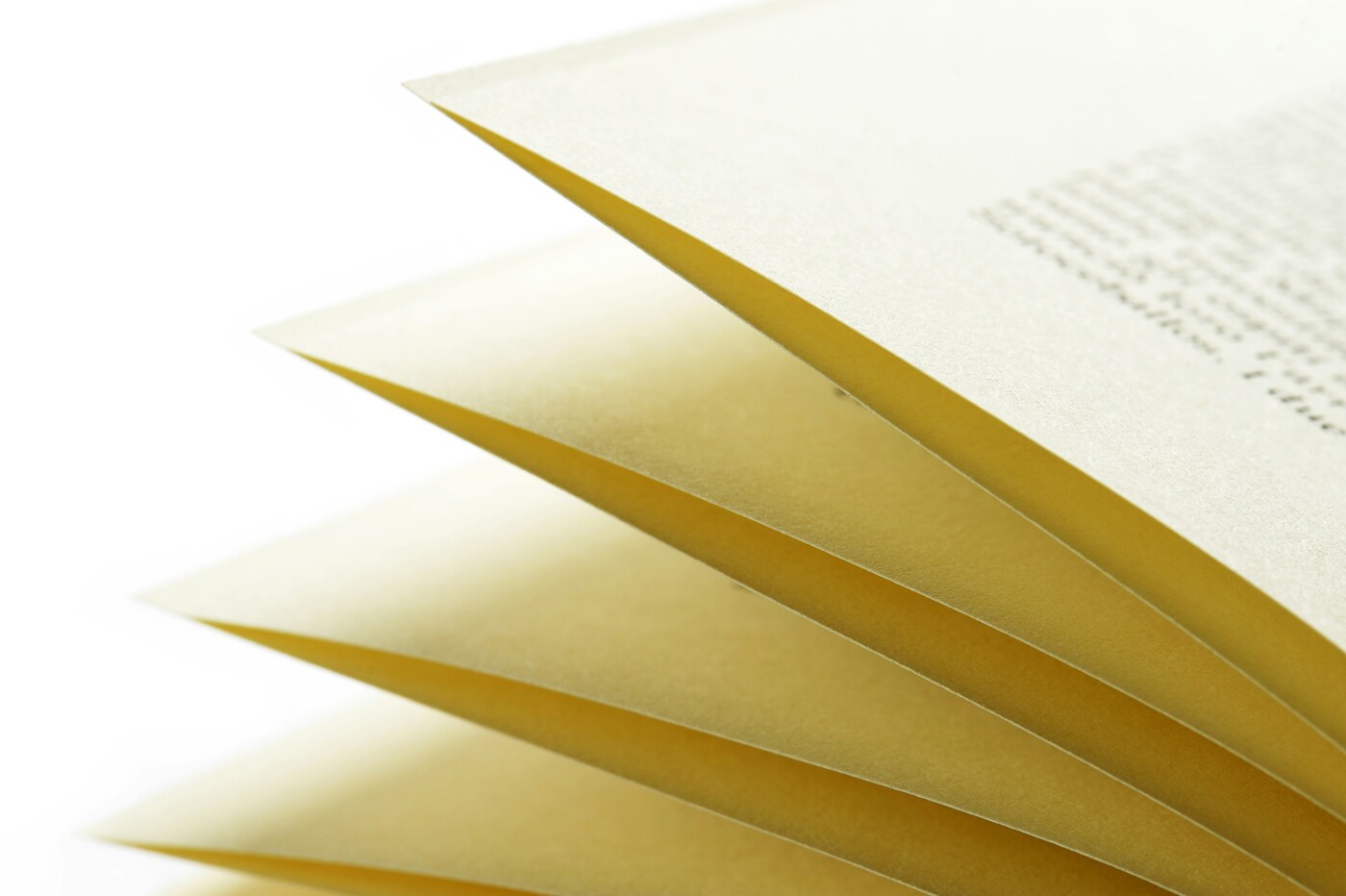 Several uncoated cream-colored book pages fanned out against a white background