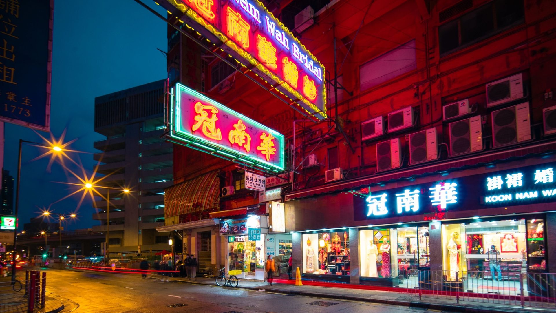 Neon signs lighting a wet Hong Kong street at night