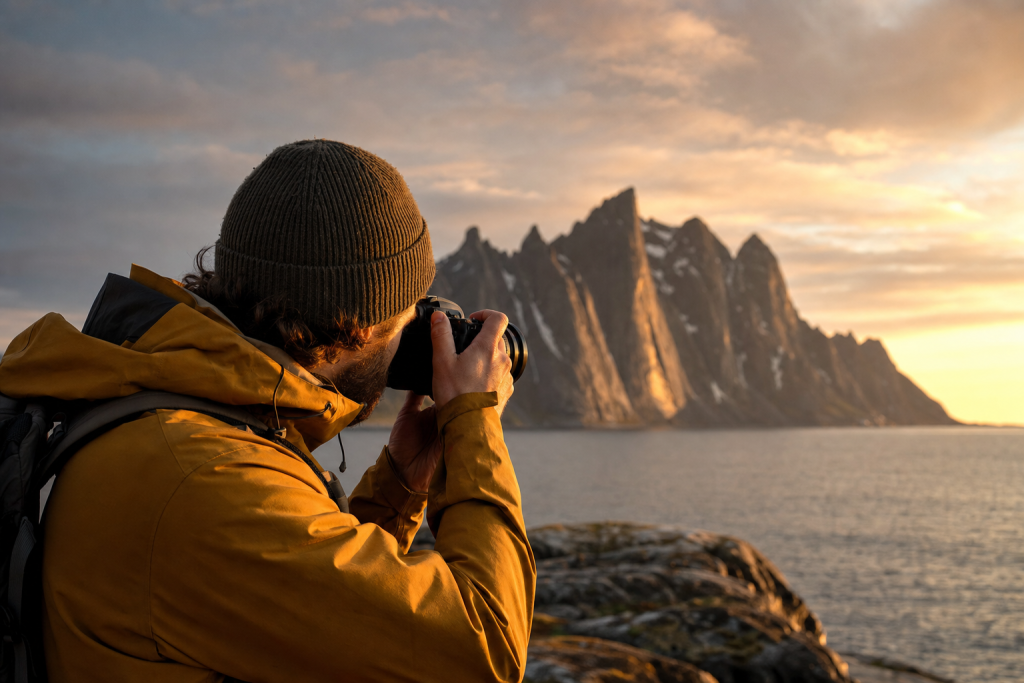 Photographer in action holding a camera at golden hour, environmental context, natural light