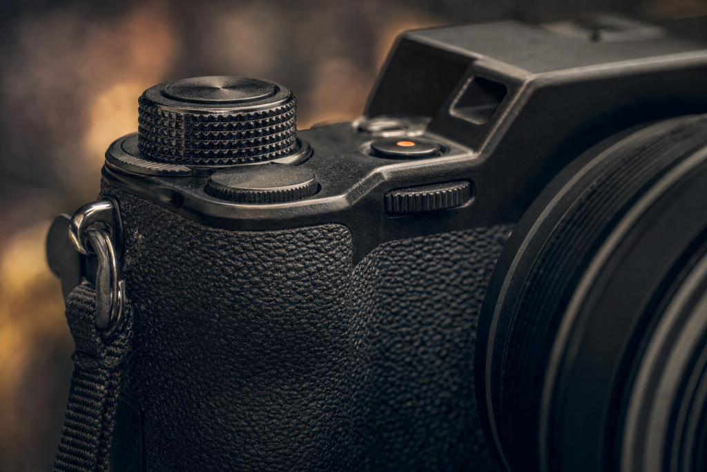 Detail shot of camera controls and grip, dramatic side lighting, macro feel, no text