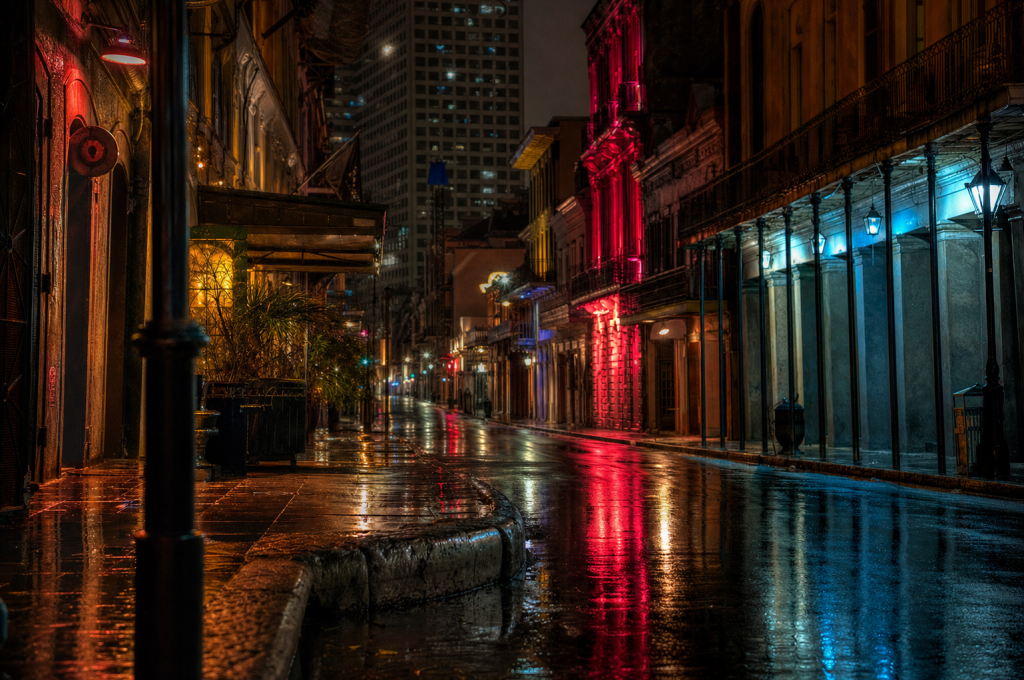 Night street scene with neon reflections on wet pavement, atmospheric mood
