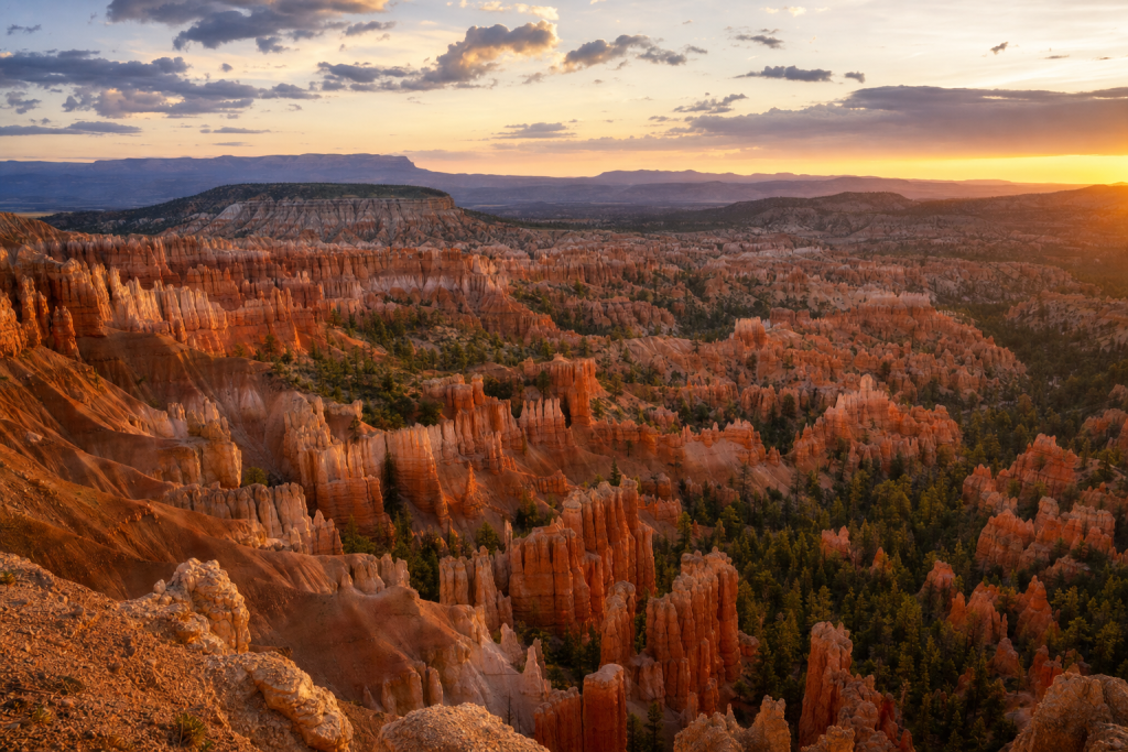 Bryce Canyon at golden hour, iconic landmarks visible, dramatic warm light
