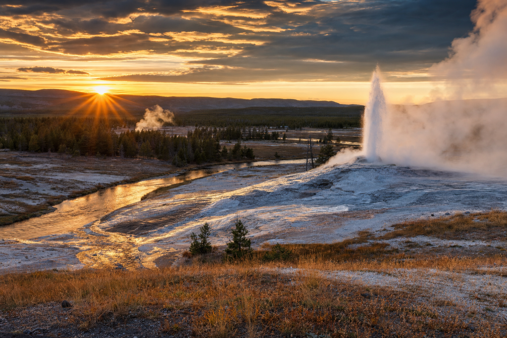 Yellowstone at golden hour, iconic landmarks visible, dramatic warm light
