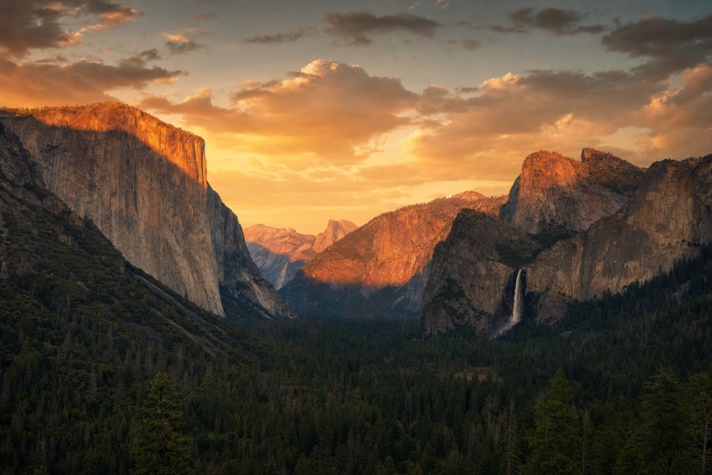 Yosemite at golden hour, iconic landmarks visible, dramatic warm light