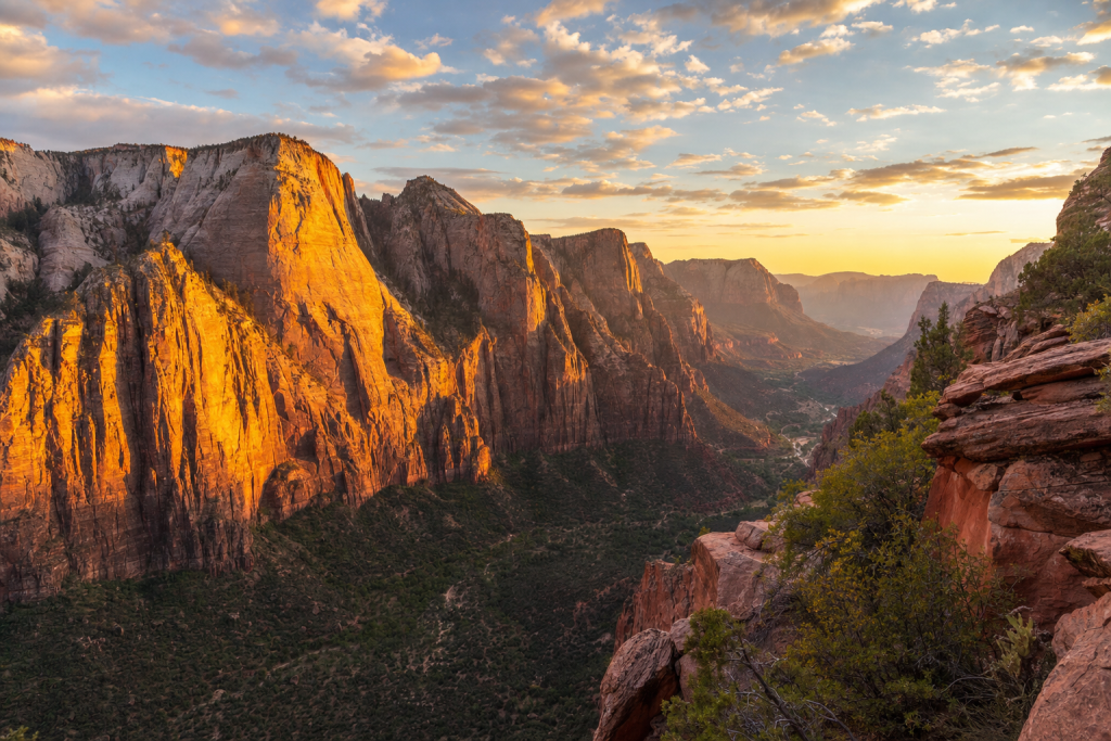 Wide-angle cinematic skyline of Zion at golden hour, iconic landmarks visible, dramatic warm light