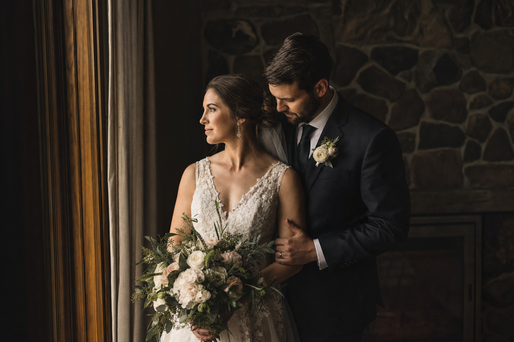 Soft window light, bride and groom in elegant attire, romantic mood