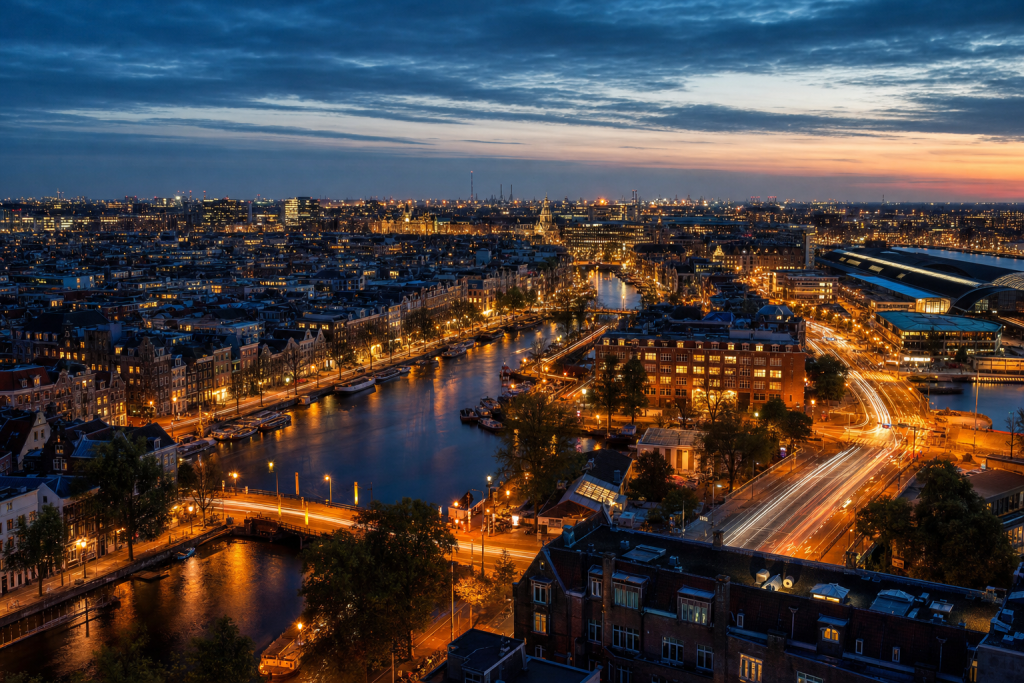 Amsterdam high-vantage cityscape at blue hour with city lights and traffic motion