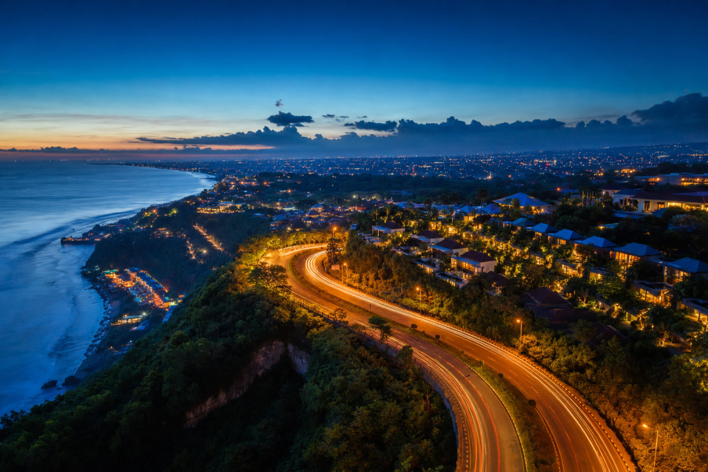 Bali high-vantage cityscape at blue hour with city lights and traffic motion