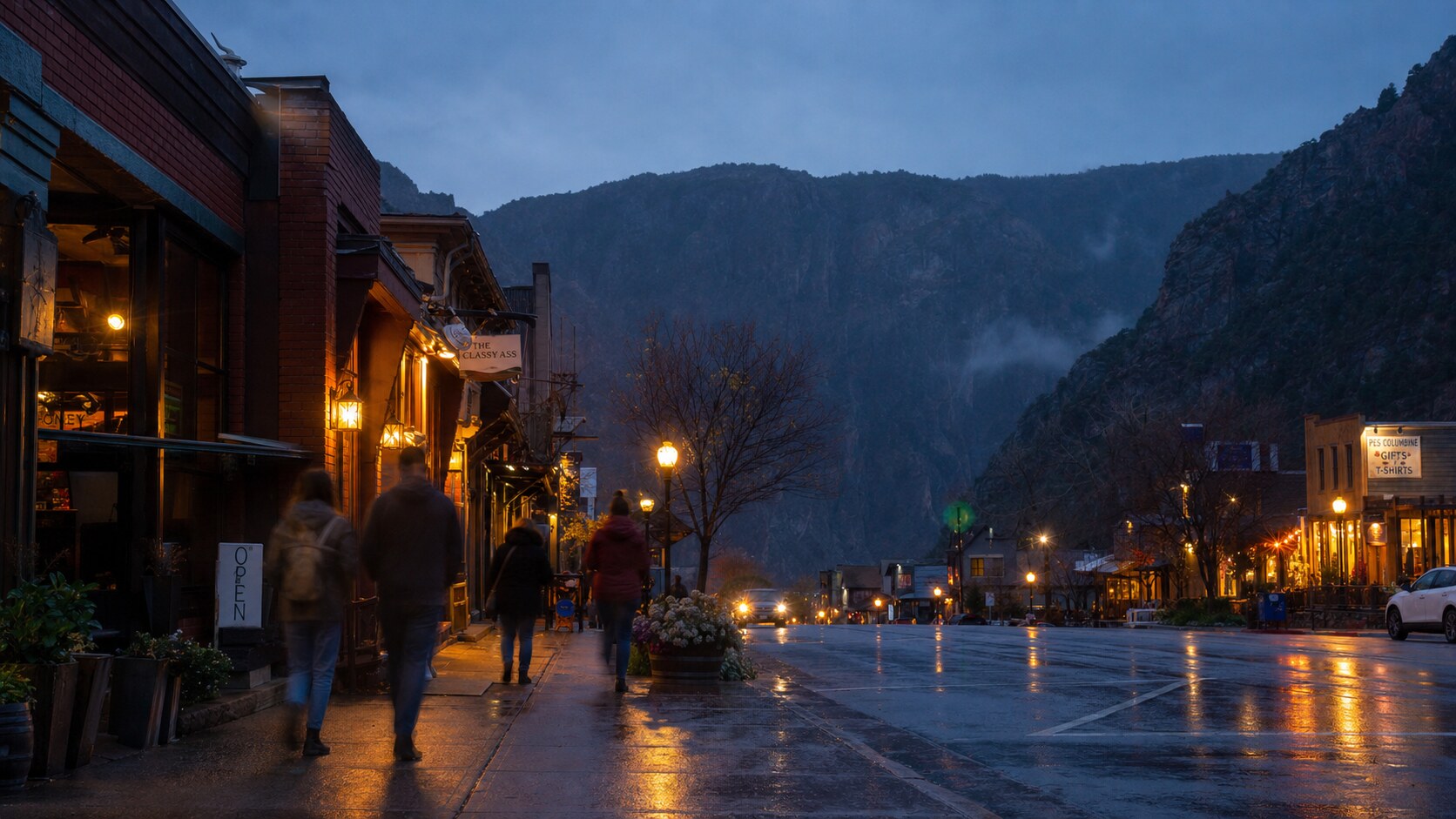Blue hour street photography in Black Canyon Of The Gunnison with wet pavement reflections and warm storefront lighting