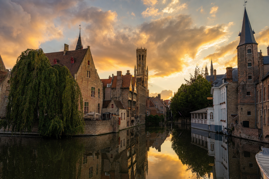 Bruges skyline at golden hour with iconic landmarks in warm light