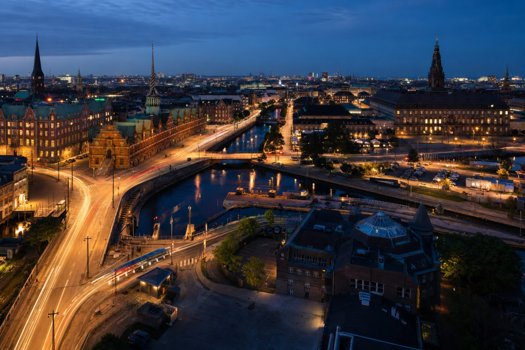 Copenhagen high-vantage cityscape at blue hour with city lights and traffic motion