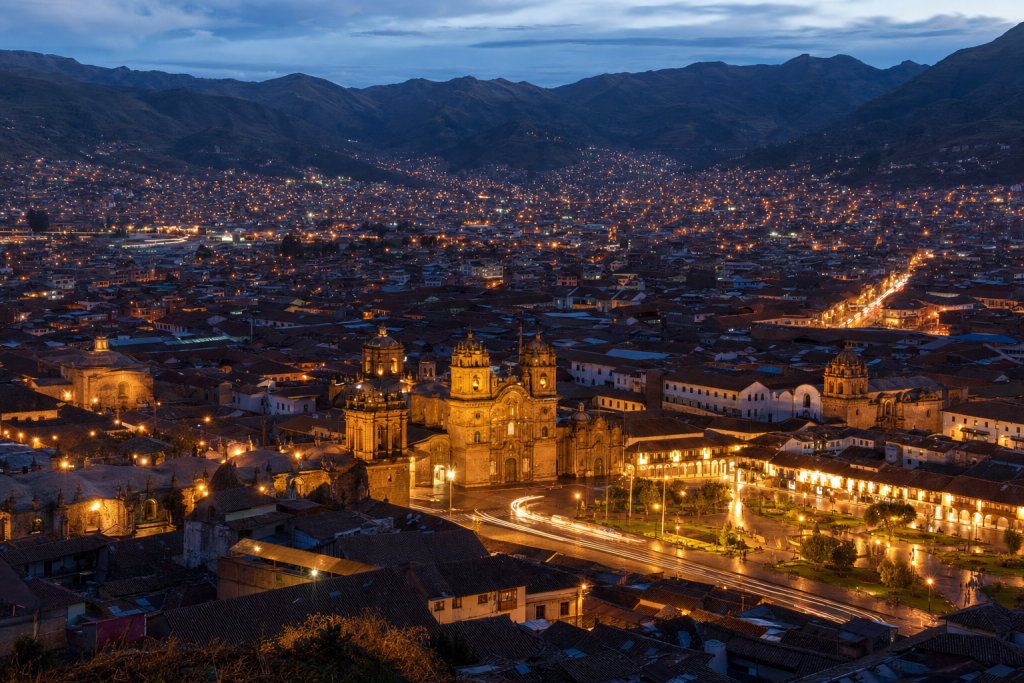Cusco high-vantage cityscape at blue hour with city lights and traffic motion