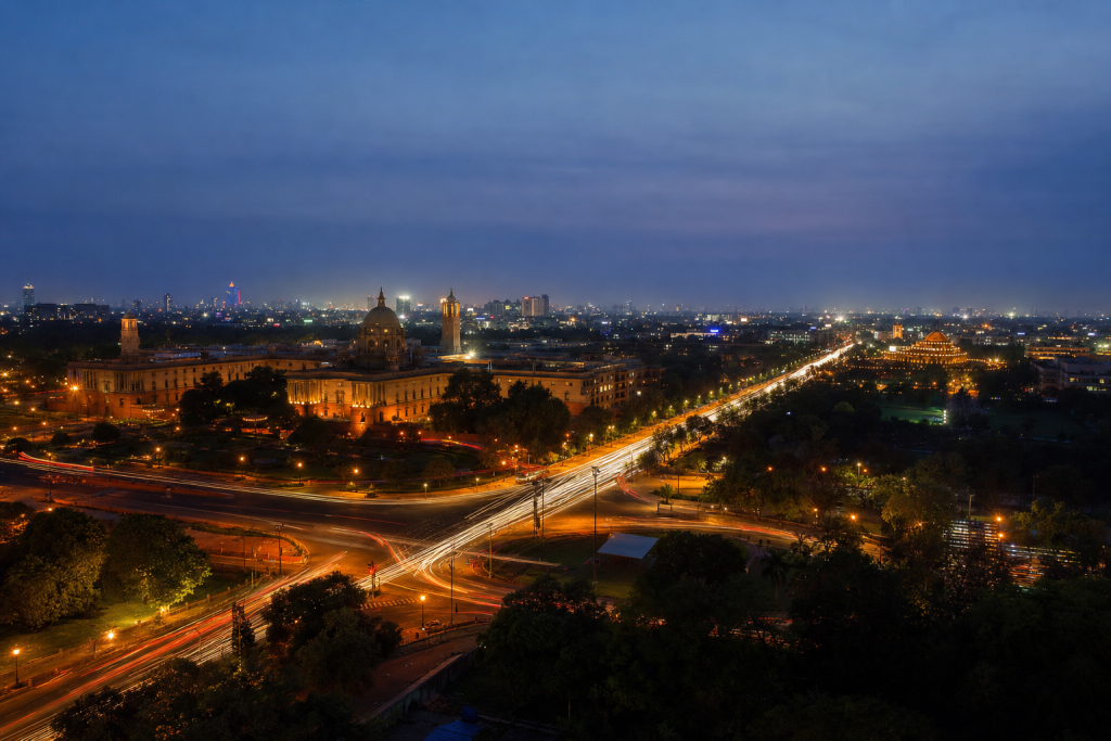 Delhi high-vantage cityscape at blue hour with city lights and traffic motion