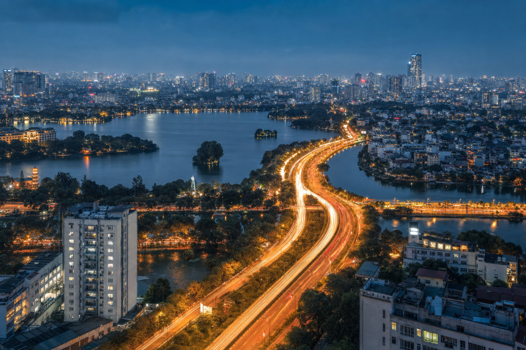 Hanoi high-vantage cityscape at blue hour with city lights and traffic motion