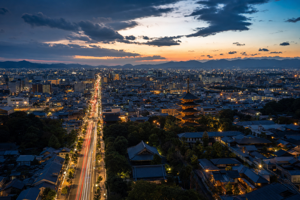 Kyoto high-vantage cityscape at blue hour with city lights and traffic motion