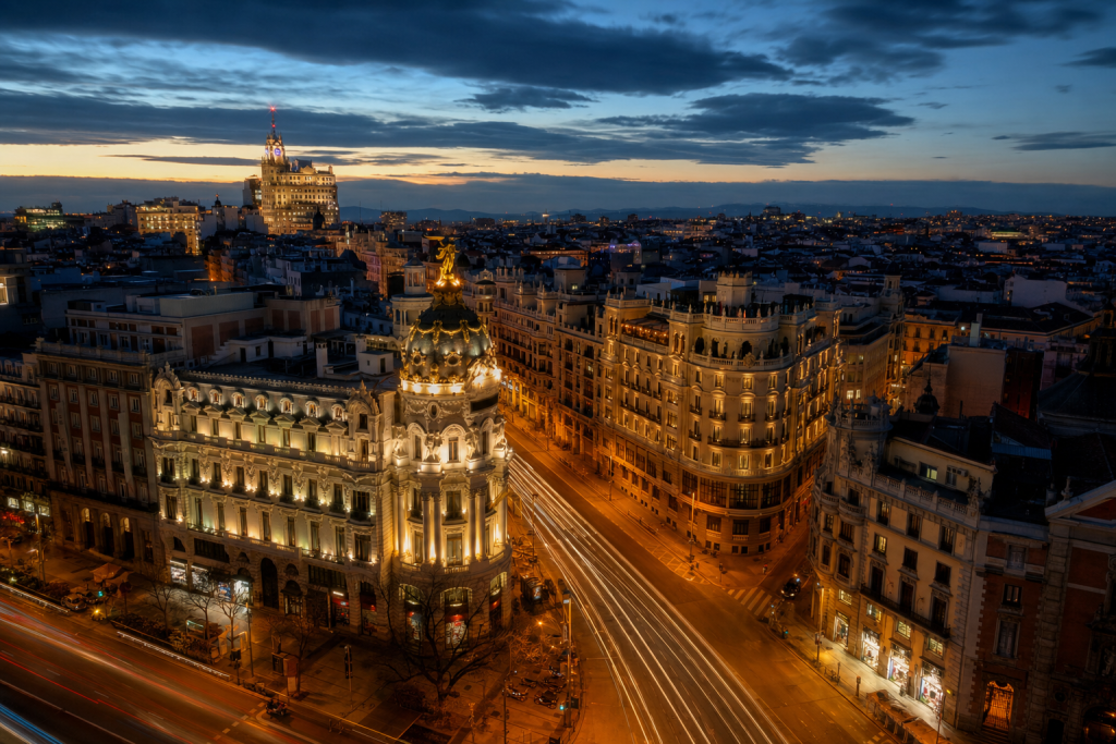 Madrid high-vantage cityscape at blue hour with city lights and traffic motion