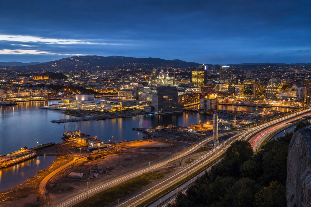 Oslo high-vantage cityscape at blue hour with city lights and traffic motion