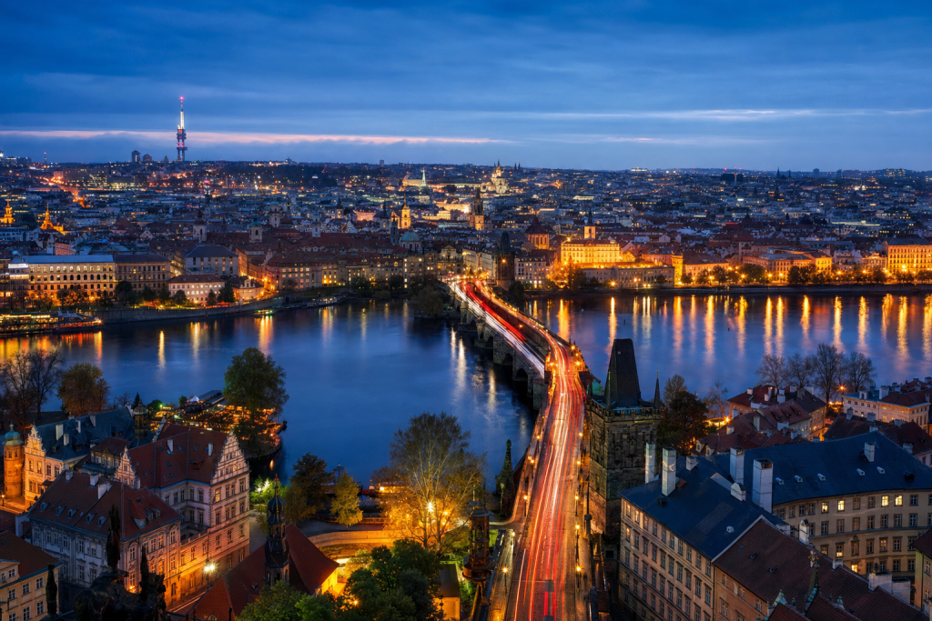 Prague high-vantage cityscape at blue hour with city lights and traffic motion
