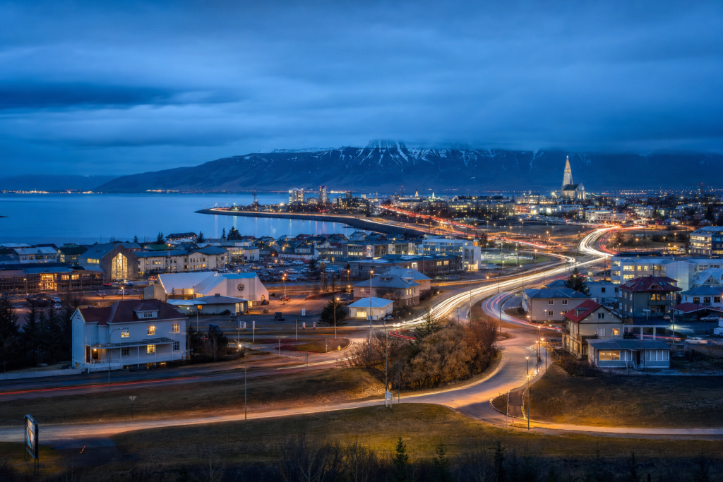 Reykjavik high-vantage cityscape at blue hour with city lights and traffic motion