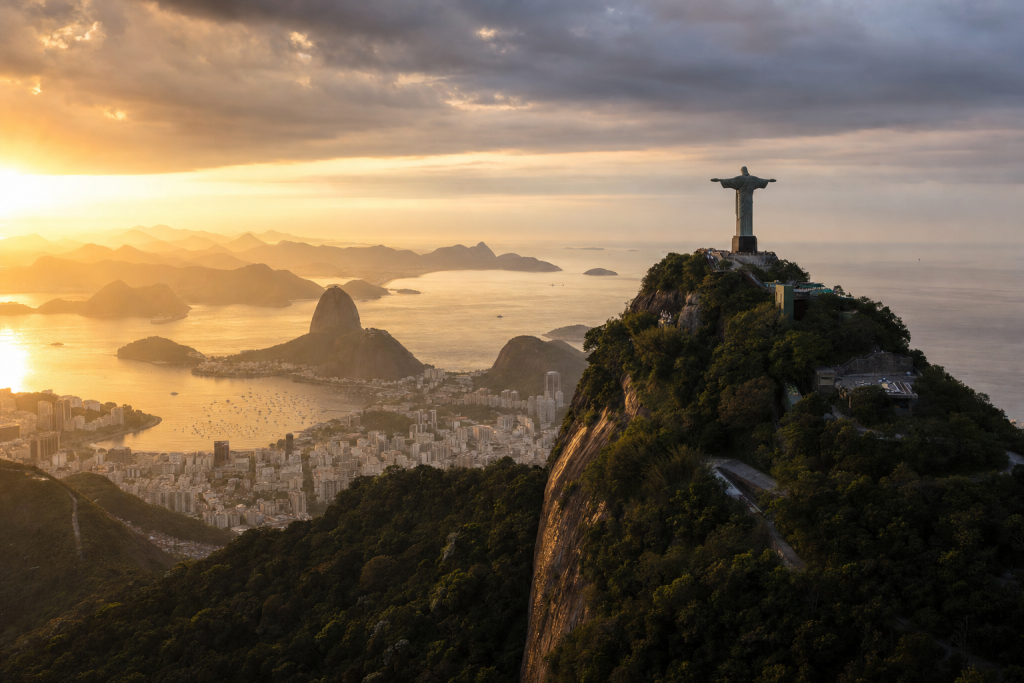 Wide-angle cinematic skyline of Rio de Janeiro at golden hour, iconic landmarks visible, dramatic warm light