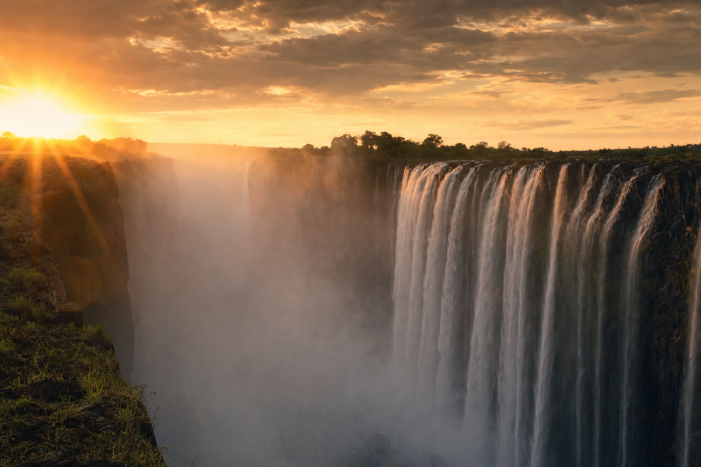 Victoria Falls skyline at golden hour with iconic landmarks in warm light