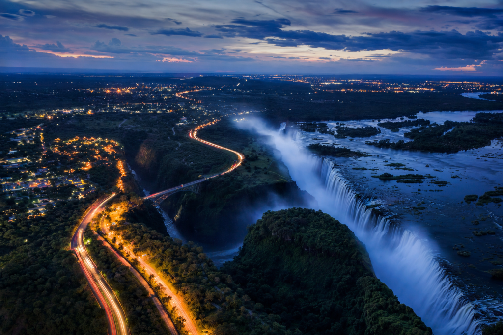 Victoria Falls high-vantage cityscape at blue hour with city lights and traffic motion