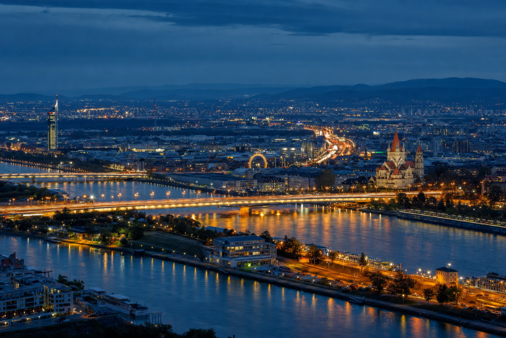 Vienna high-vantage cityscape at blue hour with city lights and traffic motion