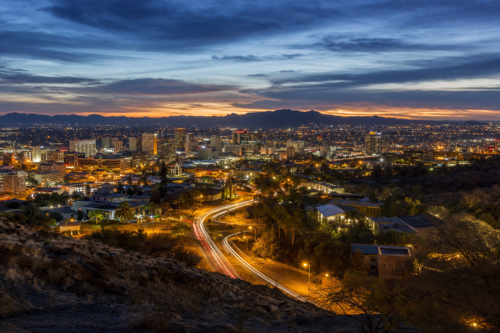 Windhoek high-vantage cityscape at blue hour with city lights and traffic motion