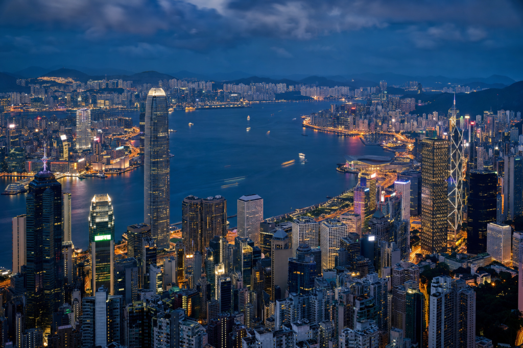 High-vantage view of Es Best Photography Spots in Hong Kong during blue hour, glowing city lights, subtle motion