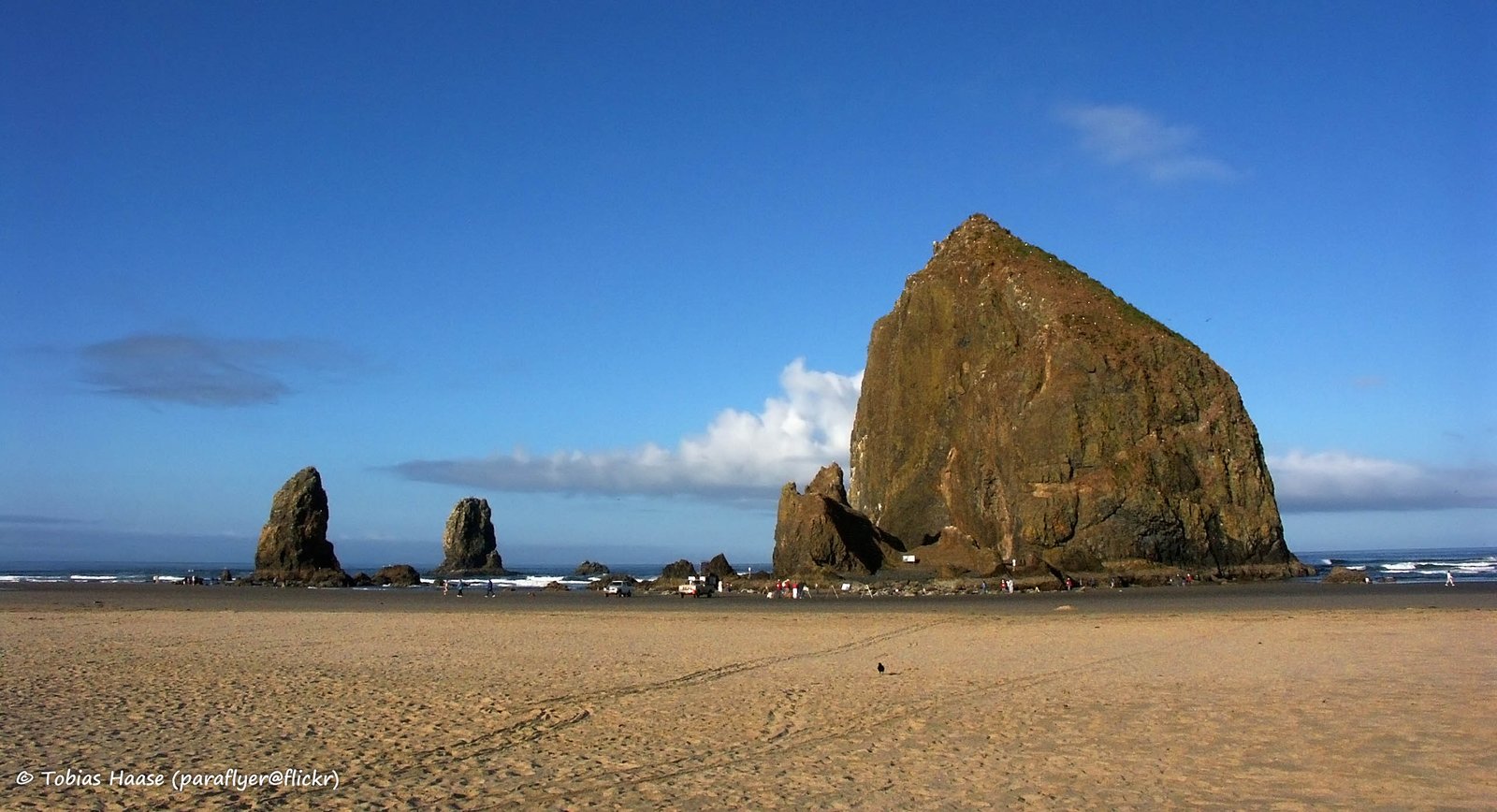 Haystack Rock monolith rising 235 feet above the beach at Cannon Beach Oregon with The Needles sea stacks in the background