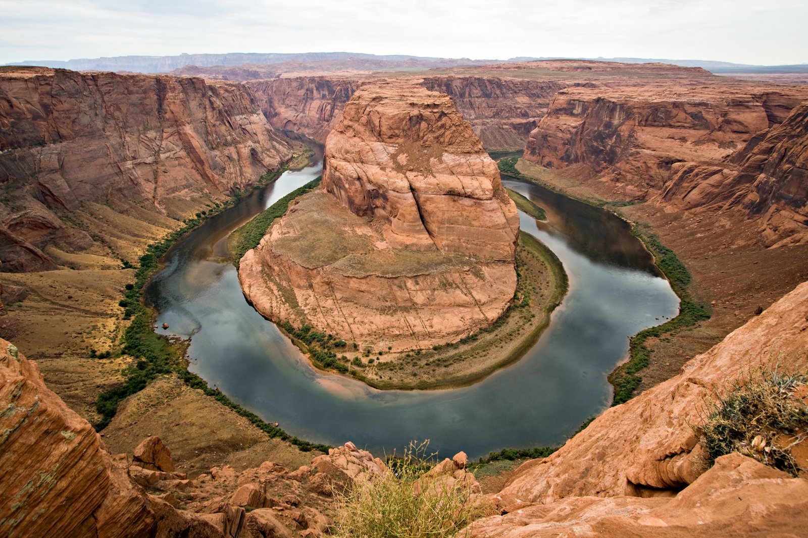 Wide-angle photograph of Horseshoe Bend showing the full Colorado River meander through Navajo sandstone cliffs near Page, Arizona, taken from the rim overlook in summer 2007 — Wikimedia Commons Featured Picture