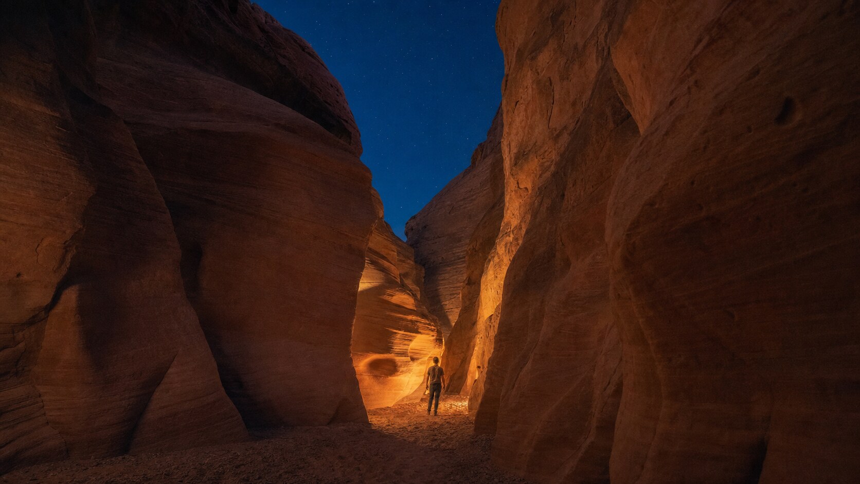Wide blue-hour view of Antelope Canyon with cobalt sky and warm artificial lighting on the landmark