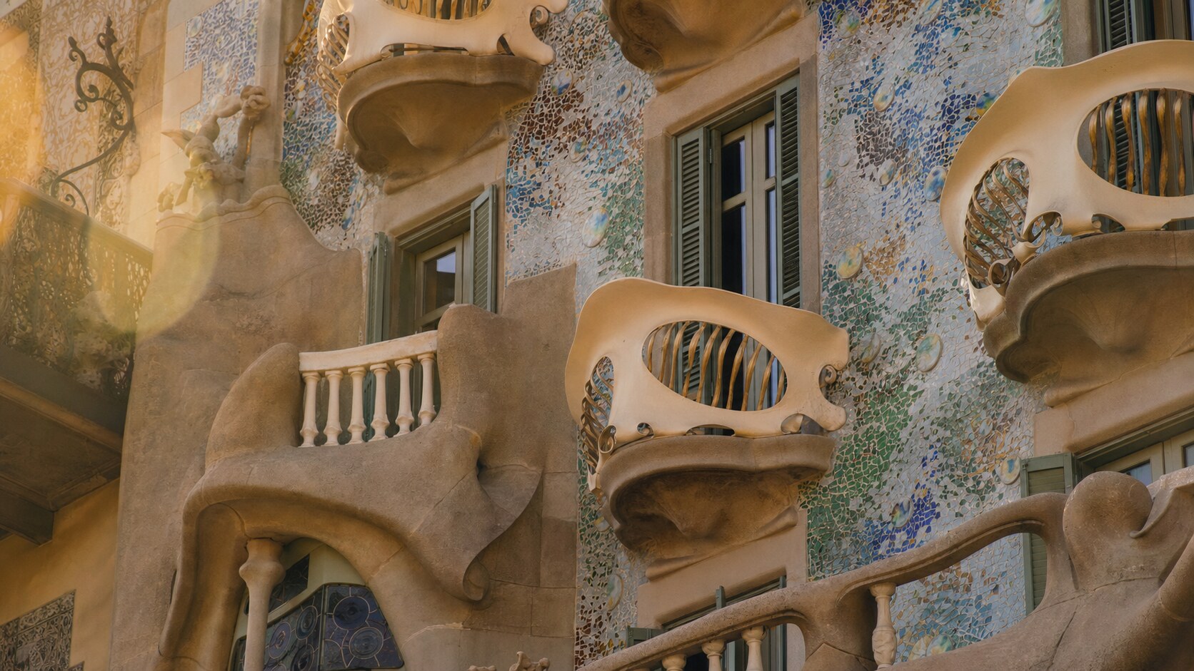 Close-up architectural detail of Casa Batllo at late afternoon, showing surface texture and material under directional sun