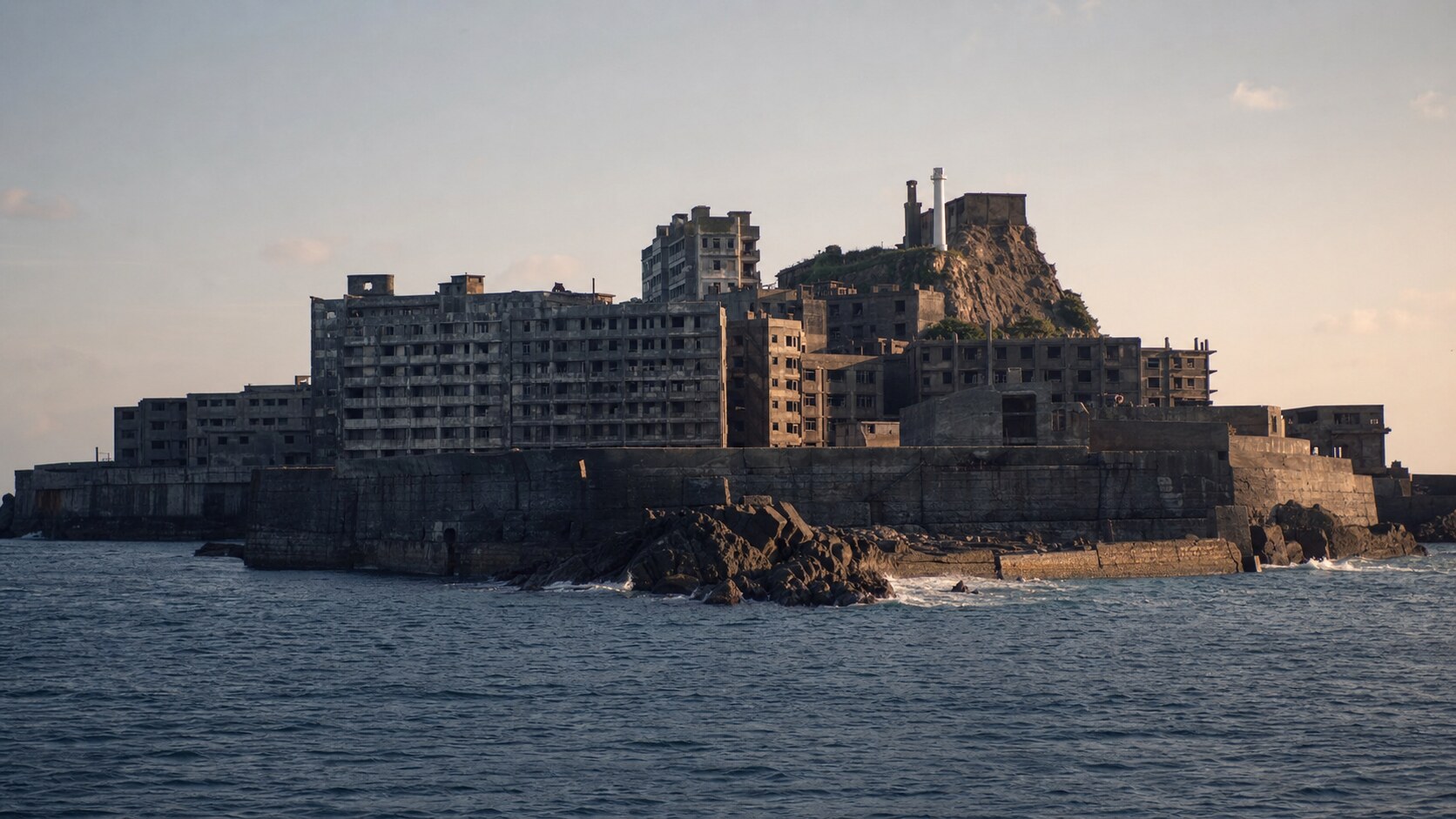 Close-up architectural detail of Hashima Battleship Island at late afternoon, showing surface texture and material under directional sun