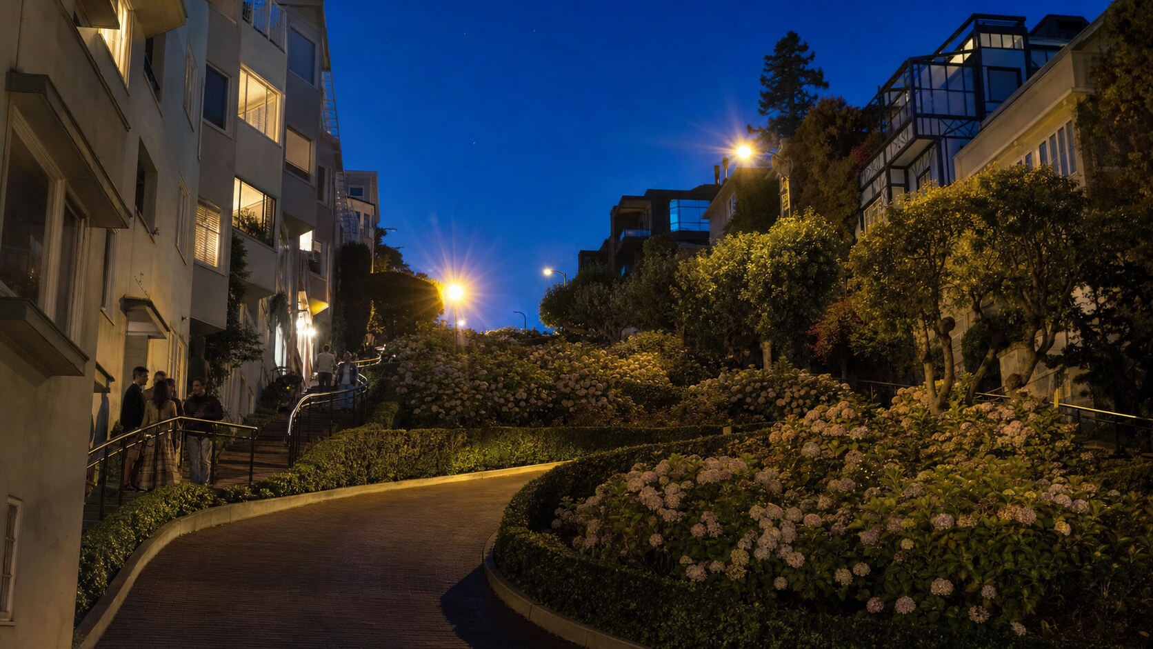 Wide blue-hour view of Lombard Street with cobalt sky and warm artificial lighting on the landmark