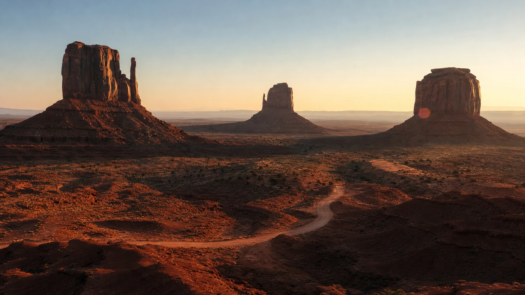 Monument Valley photographed at golden hour from the most popular hero-shot vantage point, with dramatic side-lighting on the structure