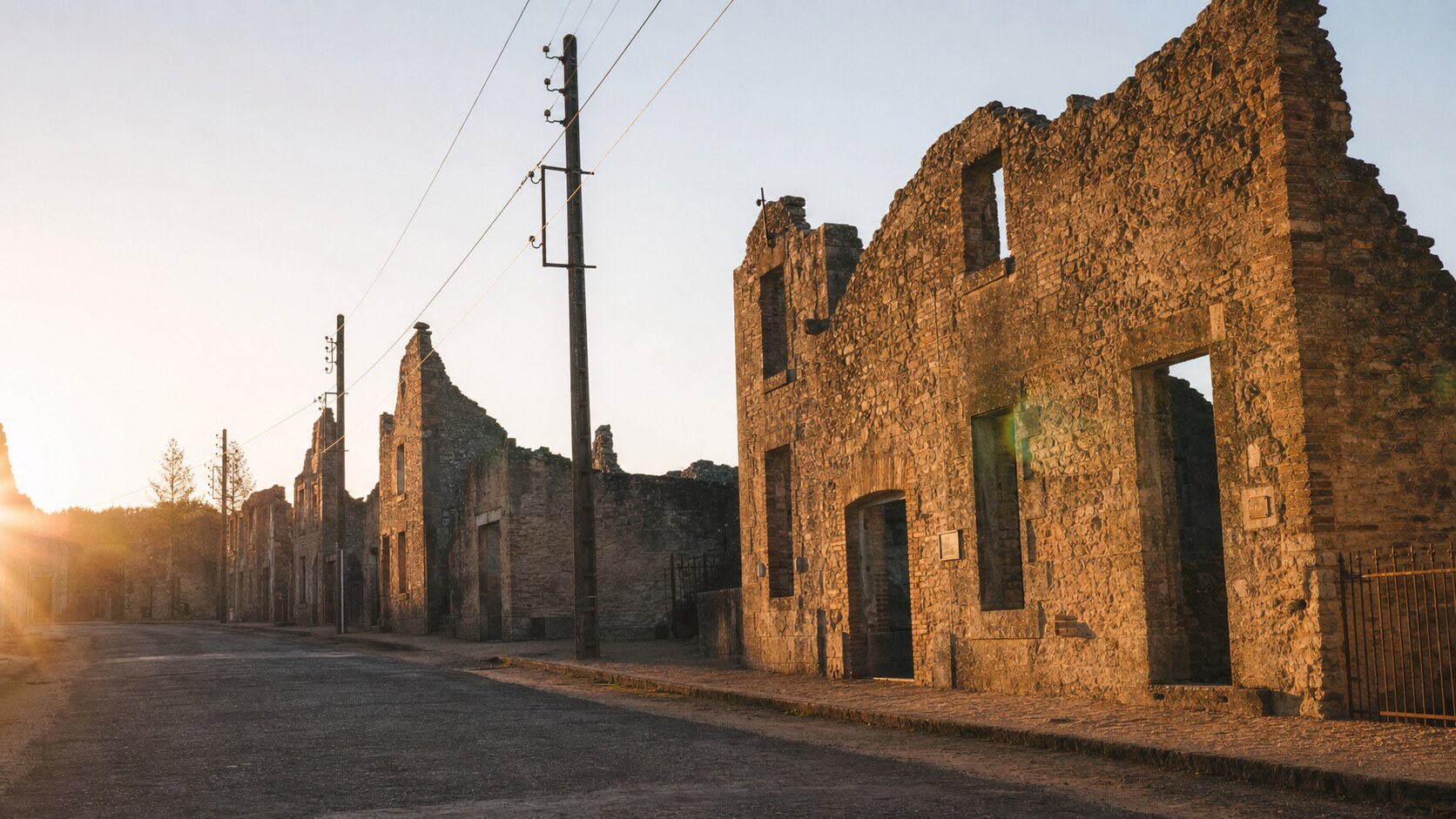Oradour Sur Glane photographed at golden hour from the most popular hero-shot vantage point, with dramatic side-lighting on the structure