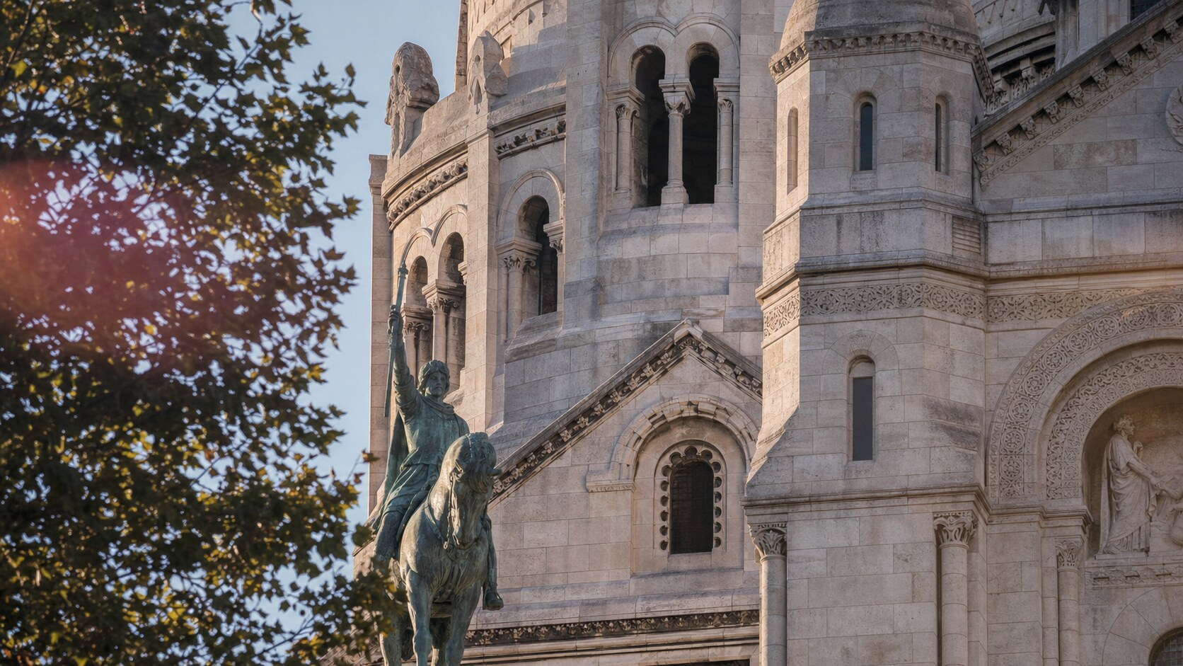 Close-up architectural detail of Sacre Coeur at late afternoon, showing surface texture and material under directional sun