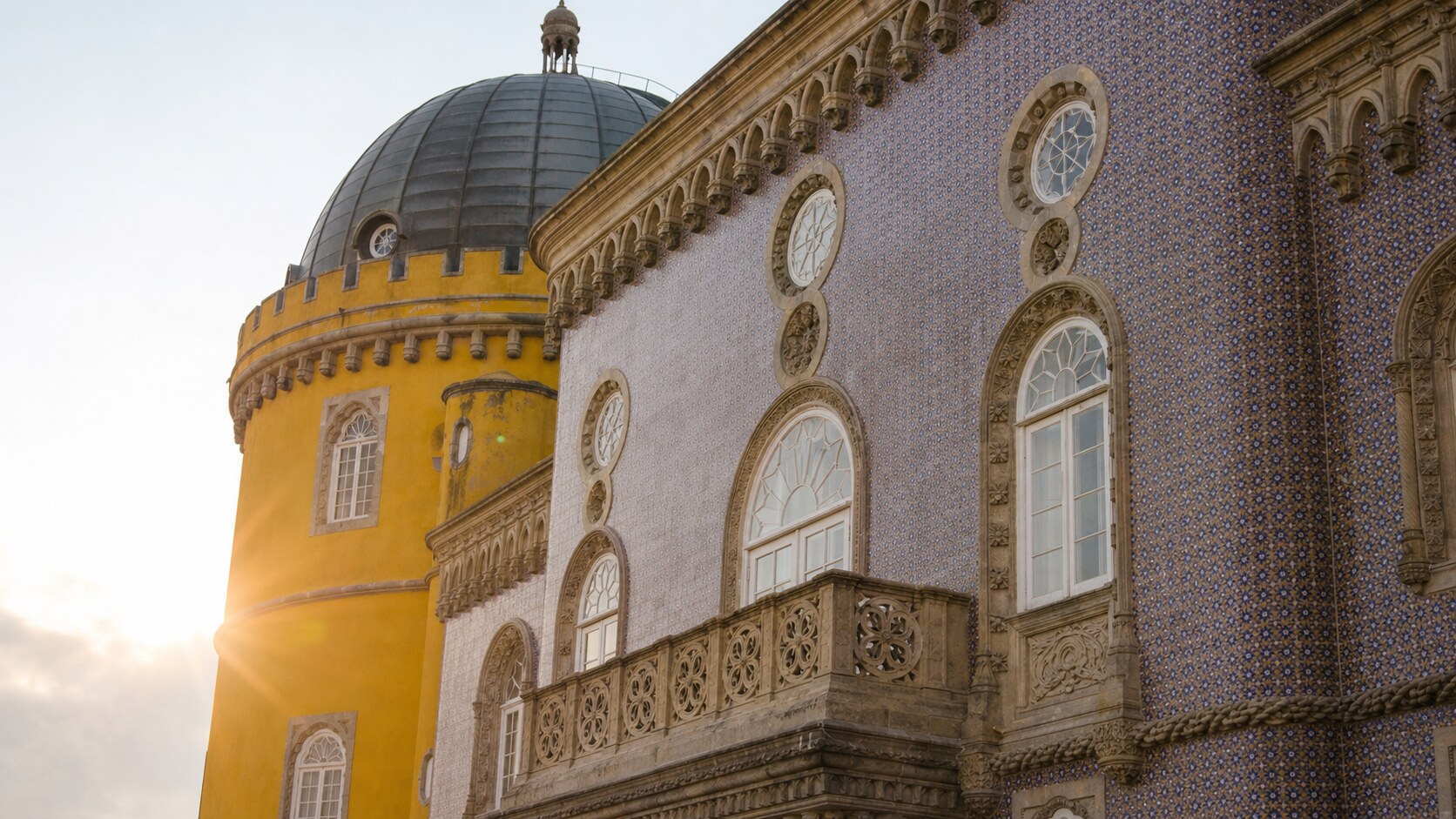 Close-up architectural detail of Sintra Pena Palace at late afternoon, showing surface texture and material under directional sun
