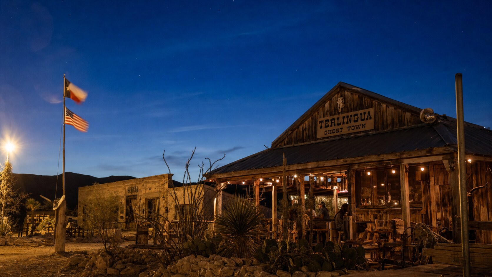 Wide blue-hour view of Terlingua Ghost Town with cobalt sky and warm artificial lighting on the landmark