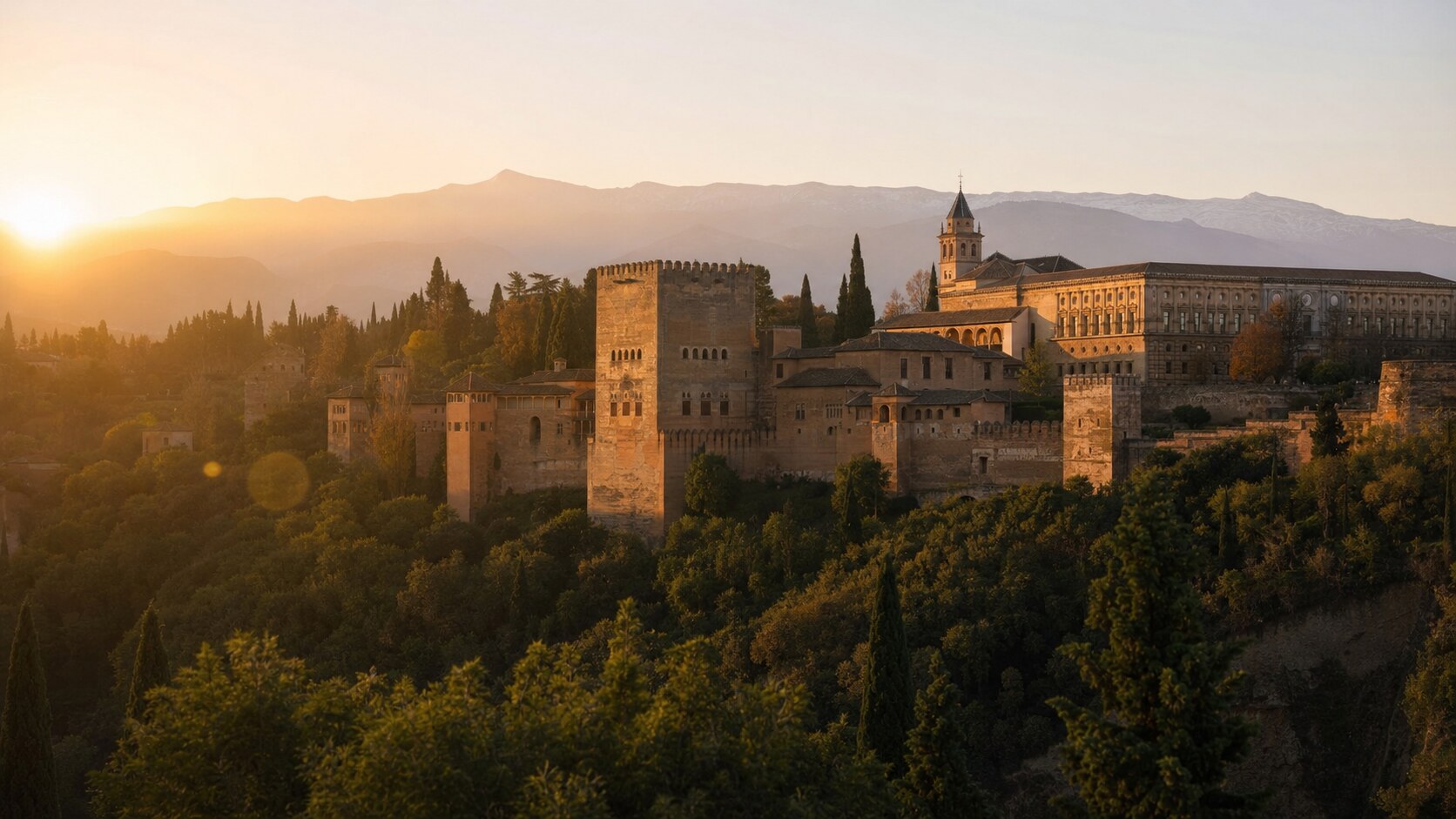 The Alhambra photographed at golden hour from the most popular hero-shot vantage point, with dramatic side-lighting on the structure