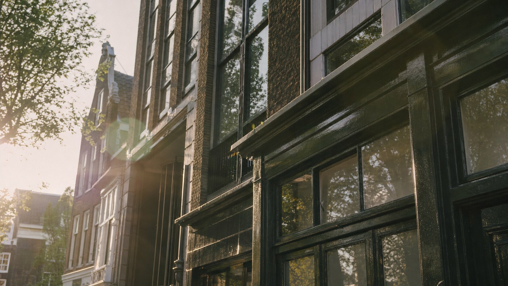 Close-up architectural detail of The Anne Frank House at late afternoon, showing surface texture and material under directional sun