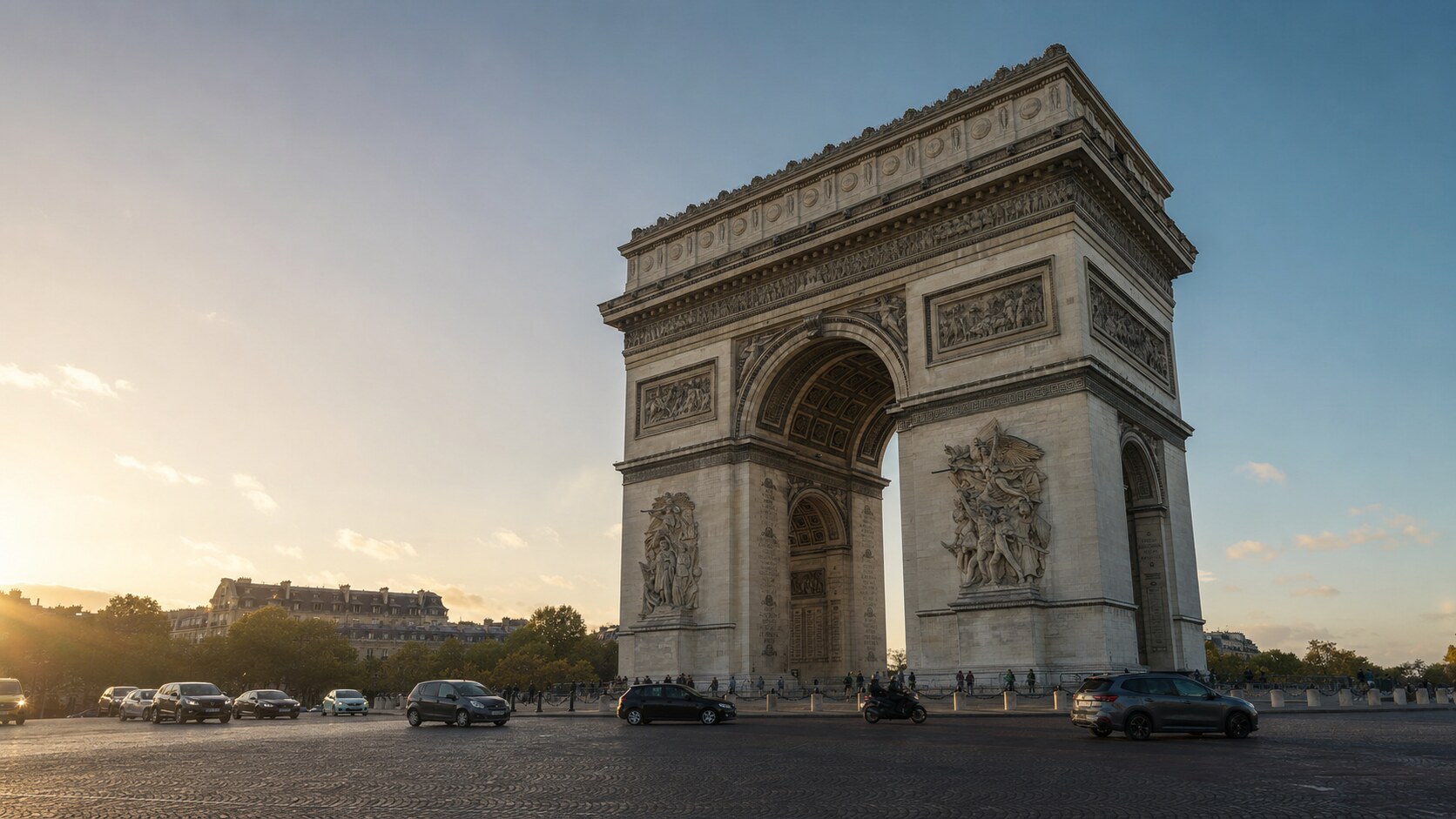 The Arc De Triomphe photographed at golden hour from the most popular hero-shot vantage point, with dramatic side-lighting on the structure