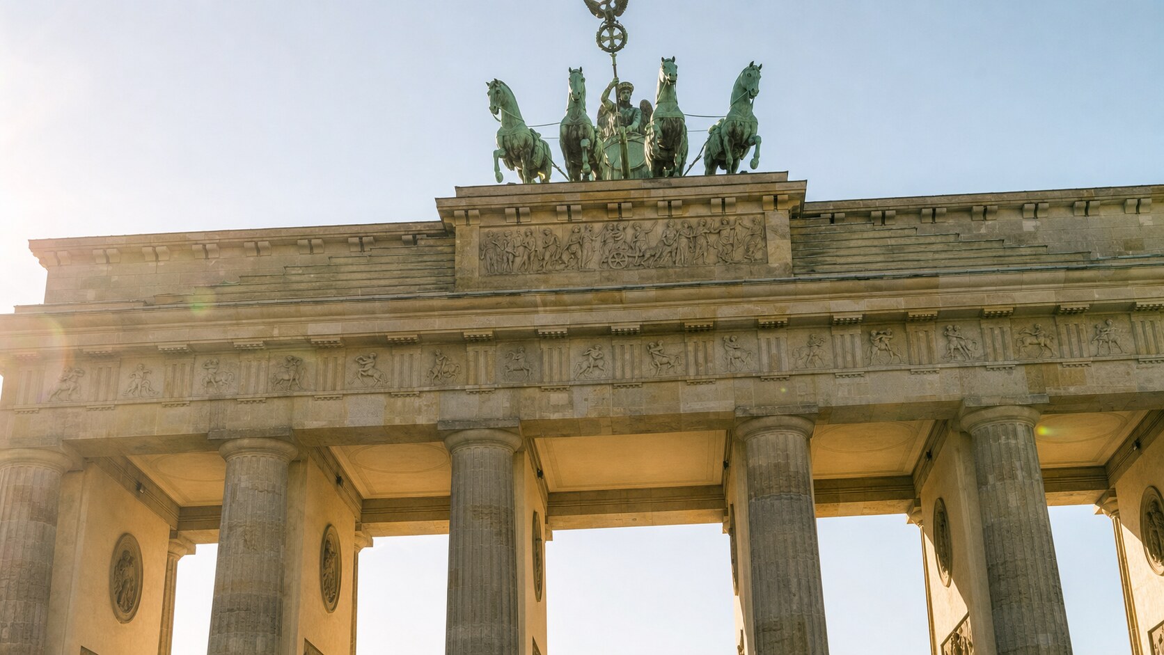 Close-up architectural detail of The Brandenburg Gate at late afternoon, showing surface texture and material under directional sun